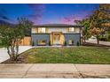 Charming home featuring a well-manicured lawn, modern exterior paint, and a pergola over the front door at 6775 Newland St, Arvada, CO 80003