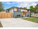 Charming home featuring a well-manicured lawn, modern exterior paint, and a pergola over the front door at 6775 Newland St, Arvada, CO 80003