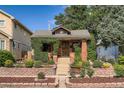 Charming home with manicured front yard, featuring brick accents and lush landscaping at 827 S Sherman St, Denver, CO 80209