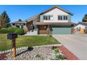 Charming two-story home featuring a manicured lawn, brick accents, and a well-kept garden at 7391 S Marion St, Centennial, CO 80122