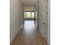 Bright hallway featuring gleaming hardwood floors and white walls, with a view to a sunlit living space at 901 Coal Bank Trl, Castle Rock, CO 80104
