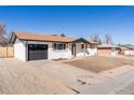 Well-maintained single-story home with gray garage door and spacious driveway at 8271 Bluebell Way, Denver, CO 80221