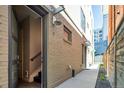 Exterior view of brick building showing a sidewalk and limited landscaping between buildings, with a view of downtown at 1323 Elati St # 3, Denver, CO 80204