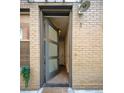 Inviting entrance with a neutral-toned brick exterior and a modern, partially frosted glass door under metal awning at 1323 Elati St # 3, Denver, CO 80204