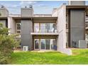Multi-level townhouse featuring a grassy lawn, private balconies, and outdoor seating at 6515 Pinewood Dr, Parker, CO 80134
