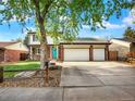 Charming two-story home with a well-manicured lawn, brick accents, and a three-car garage on a sunny day at 13935 E Idaho Pl, Aurora, CO 80012