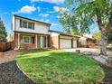 Charming two-story home with a well-manicured lawn, brick accents, and a three-car garage on a sunny day at 13935 E Idaho Pl, Aurora, CO 80012