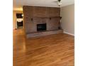 Inviting living room featuring a striking brick fireplace, complemented by gleaming hardwood floors at 8542 W 10Th W Ave, Lakewood, CO 80215