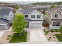 Aerial view of a gray two-story home with a large driveway and well-maintained landscaping at 3319 Starry Night Loop, Castle Rock, CO 80109