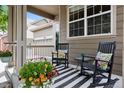 Cozy front porch with rocking chairs, colorful pillows, and a striped rug at 3540 Brushwood Dr, Castle Rock, CO 80109