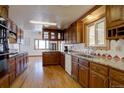 Spacious kitchen features wood cabinetry, granite countertops, hardwood floors, and modern appliances at 11810 Mesa View Rd, Larkspur, CO 80118