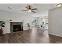 A bright living room featuring a fireplace, ceiling fan, and dining area with sliding doors to a balcony at 3051 S Ursula Cir # 302, Aurora, CO 80014