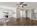 Open-concept living space with hardwood floors, ceiling fan, adjacent dining, and access to other rooms at 3051 S Ursula Cir # 302, Aurora, CO 80014