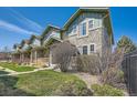 Street view of townhomes with stone accents, green siding, manicured lawns, and welcoming front porches at 552 S Mobile Pl, Aurora, CO 80017