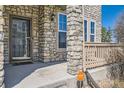 Close-up of the front porch with stone pillars, a Vivint SmartHome sign, and a screen door at 552 S Mobile Pl, Aurora, CO 80017