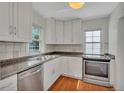 Bright kitchen features white cabinets, stainless steel appliances, and granite countertops, offering a clean and modern cooking space at 4480 S Pennsylvania St, Englewood, CO 80113