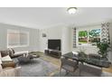 Bright living room features wood floors, stylish decor, and large windows offering plenty of natural light at 4480 S Pennsylvania St, Englewood, CO 80113
