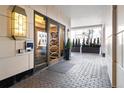 Grand building entrance with tiled walkway, decorative lighting, and manicured greenery at 1891 Curtis St # 1820, Denver, CO 80202