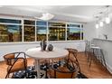 Bright dining area with hardwood floors and floor to ceiling windows overlooking a city skyline at 1891 Curtis St # 1820, Denver, CO 80202