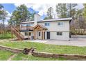 Charming two-story home featuring a wooden deck, inviting entryway, and lush green lawn at 721 Forest View Rd, Monument, CO 80132