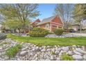 Well-maintained home with a lush green lawn and mature trees providing shade and curb appeal at 8801 W 65Th Ave, Arvada, CO 80004