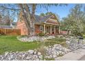 Beautifully landscaped front yard with a charming home featuring a cozy front porch at 8801 W 65Th Ave, Arvada, CO 80004