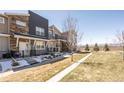 Townhome exteriors with private patios, front walkways, and a common grass area at 821 Robert St, Longmont, CO 80503