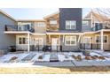 Inviting townhome features a mix of stone and gray siding, a white front door, and charming front patios at 821 Robert St, Longmont, CO 80503