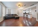 Spacious living room featuring hardwood floors, a leather couch, and an open layout to the kitchen at 15956 E Geddes Dr # 140, Aurora, CO 80016