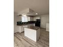 Bright kitchen featuring an island, white cabinets, and black appliances at 14598 E Evans Ave, Aurora, CO 80014