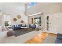 Bright living room featuring vaulted ceilings, stylish decor, and natural light at 7065 Campden Pl, Castle Pines, CO 80108