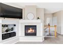 Close up of the fireplace in the living room, with a display shelf to the side, and the stairwell behind at 3972 S Shawnee Way, Aurora, CO 80018