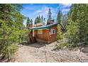 Cozy exterior view of the rear of this cabin with a partial solar roof at 542 Harris Dr, Idaho Springs, CO 80452