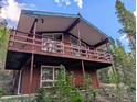 Exterior angle view of a two-story home with a large wooden balcony at 542 Harris Dr, Idaho Springs, CO 80452