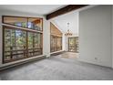 Bright living room boasting large windows with scenic views, complemented by vaulted ceilings and wood beams at 542 Harris Dr, Idaho Springs, CO 80452