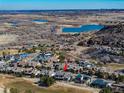 Stunning aerial view of a luxury home in a beautiful community near a pristine lake and rolling hills at 8033 Galileo Way, Littleton, CO 80125