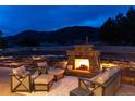 Cozy backyard patio featuring an outdoor fireplace with comfortable seating and scenic mountain views at 8033 Galileo Way, Littleton, CO 80125