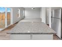 Kitchen island with granite countertops in an open floor plan at 2244 Alyssa St, Fort Lupton, CO 80621