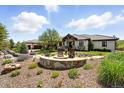 Expansive property featuring a charming fire pit, lush landscaping, and a well-maintained home exterior with a tile roof at 3720 Ranch Hand Ln, Castle Rock, CO 80104