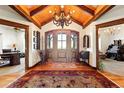 Grand home foyer boasts a wooden ceiling, chandelier, and large wood front door with sidelights at 3720 Ranch Hand Ln, Castle Rock, CO 80104