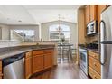 Modern kitchen open to the dining area featuring stainless steel appliances and granite counters at 18669 Stroh Rd # 10208, Parker, CO 80134