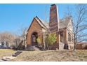 Charming brick home with arched entry, distinctive chimney, and landscaped front yard at 2960 Ash St, Denver, CO 80207