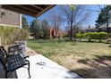 A bench seat and concrete patio with a grassy area with benches, tables, and trees at 2716 E Otero Pl # 6, Centennial, CO 80122