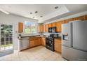 Well-lit kitchen with stainless steel appliances, wooden cabinets, and sliding glass door access at 2141 Coronado N Pkwy # C, Denver, CO 80229