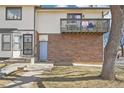 Townhouse exterior showcasing brick facade, balcony, and well-maintained lawn at 1868 S Ammons St # D, Lakewood, CO 80232