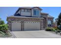 Two-story home with brick exterior, an attached two-car garage, and well-maintained landscaping at 973 Orion Way, Castle Rock, CO 80108