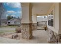 Cozy covered porch enhanced by stone pillars, patterned stone flooring, and a decorative lion statue at 10619 N Osceola Dr, Westminster, CO 80031
