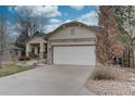 Exterior shot showcasing a home's neutral color scheme, stone accents, and spacious two-car garage with concrete driveway at 10619 N Osceola Dr, Westminster, CO 80031