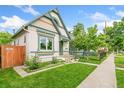Beautiful home showcasing manicured lawn, tidy landscaping, and a black iron fence surrounding the property at 3613 Julian St, Denver, CO 80211