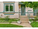 Inviting front entrance with decorative glass door, lush flower beds, and well-kept lawn at 3613 Julian St, Denver, CO 80211